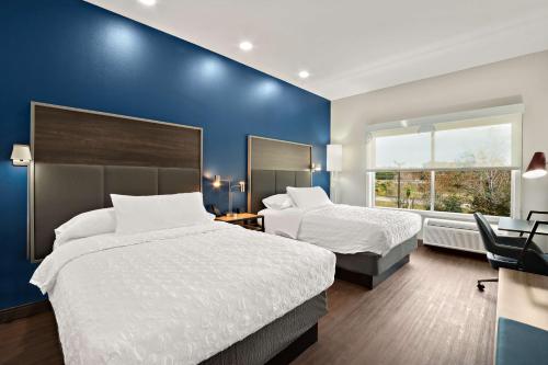 桑蒂Tru By Hilton Santee的一间卧室设有两张床和蓝色的墙壁