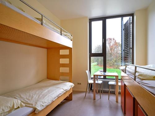 埃希特纳赫埃希特纳赫青年旅社的一间卧室配有双层床、一张桌子和一张书桌