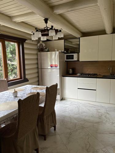 米戈韦Goral cottage in Migovo的厨房配有桌椅和冰箱。