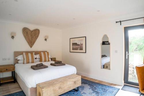 滕比Hideaway Cottages - Greenacres Estates的卧室配有白色的床和木桌