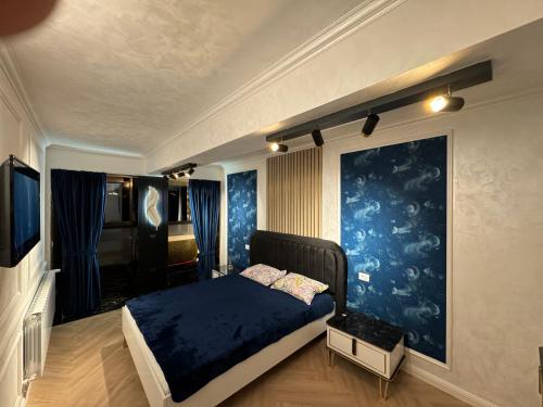 苏恰瓦FancyLux Apartament的一间卧室设有一张床和蓝色的墙壁