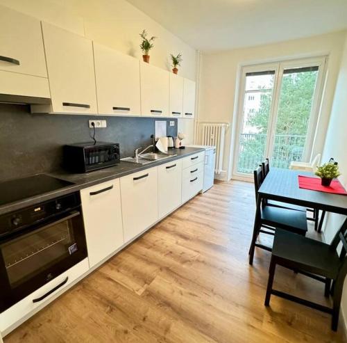 布尔诺Centrum apartment的厨房配有白色橱柜、桌子和用餐室。