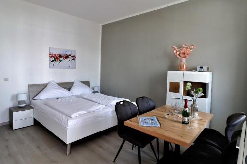 萨斯尼茨Villa Azur的一间卧室配有一张床和一张桌子及椅子