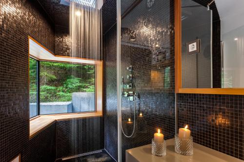 克拉尼斯卡戈拉Jasna Mansion的浴室配有淋浴和2个水槽上的蜡烛