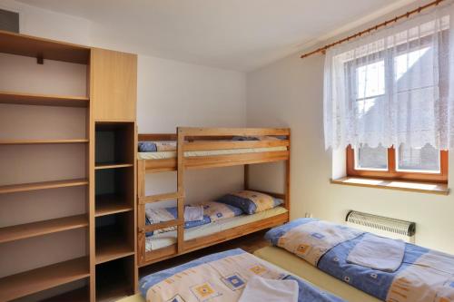 圣科维斯Penzion Skála的一间卧室设有两张双层床和一扇窗户。
