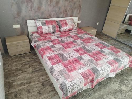 PernikHeart of Pernik apartment的一间卧室配有一张带红白色棉被的床