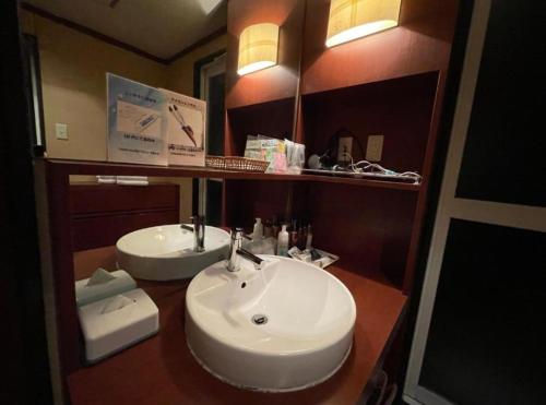 舞鹤市アルカディア的浴室设有白色水槽和镜子