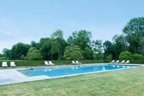 阿姆博斯Château de Perreux, The Originals Collection的庭院内带躺椅的游泳池