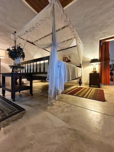 康提伽尔坎达瓦拉瓦酒店的一间卧室配有一张带大伞的床