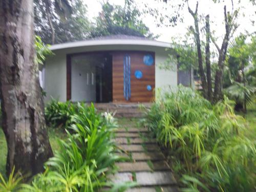 特里凡得琅Michael Leisure & Ayurveda Retreat的花园里的一座小房子,设有木门
