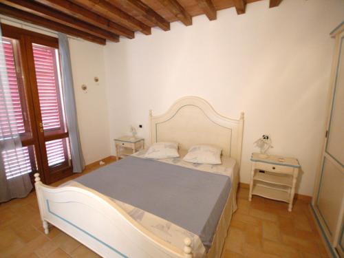 里奥马里纳Villaggio Di Mezzo Ortano的卧室配有白色的床和桌子
