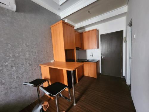 万隆Metro Suits Apartment Bandung的一个带桌子和两把椅子的小厨房