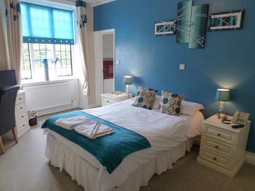 布莱克伍德梅斯庄园乡村酒店的一间卧室配有一张蓝色墙壁的床
