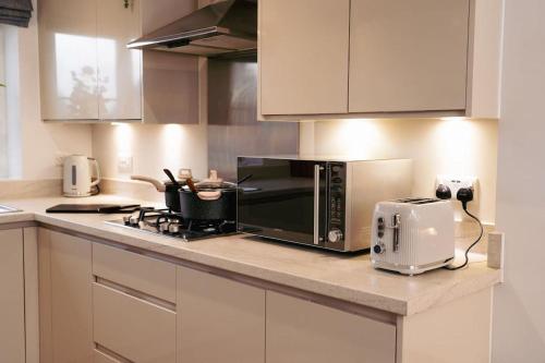 纽尼顿Luxury 4Bed Townhouse - Parking+Wi-Fi+Amenities的厨房柜台配有微波炉和烤面包机。