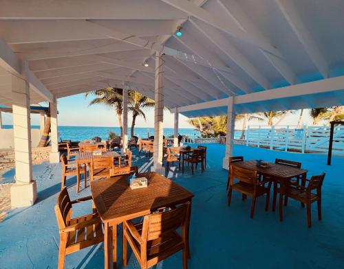 HermitageExuma Palms Resort的海滩上的餐厅,配有桌椅