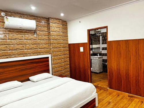 法里达巴德Hotel Walk Inn的一间卧室设有一张床和砖墙