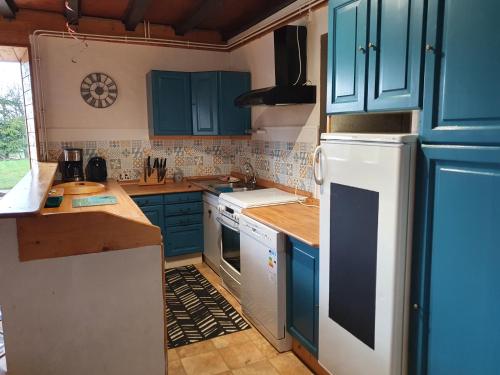 莱鲁斯Gîte du Grand Cher的厨房配有蓝色橱柜和白色冰箱