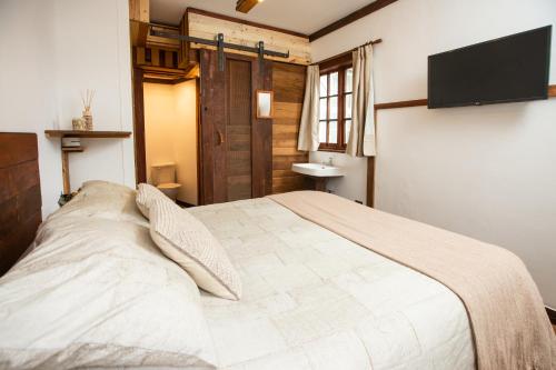 维纳德马RUSTIKA Bed and breakfast的一间卧室配有一张大床和一台平面电视