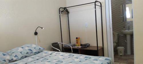 马里利亚Kitnet Marília的一间卧室配有一张床、一张书桌和一面镜子