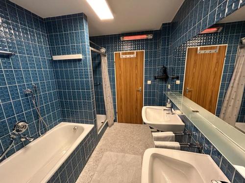 翁特尔韦森Ferienwohnung Am Nussbaum的蓝色瓷砖浴室设有浴缸和水槽