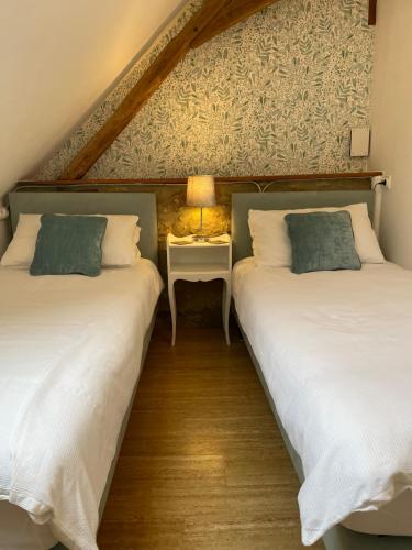 Corgnac-sur-lʼIsleCARIAD LA REBEUSE的两张睡床彼此相邻,位于一个房间里