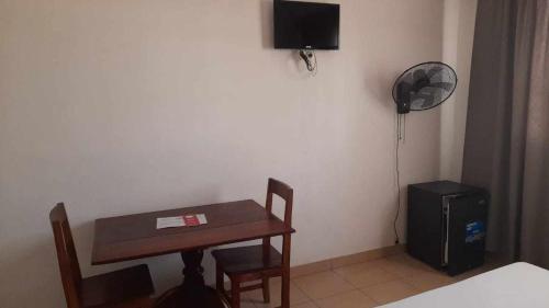 马哈赞加RAOOF HOTEL的客房设有书桌、桌子和风扇。