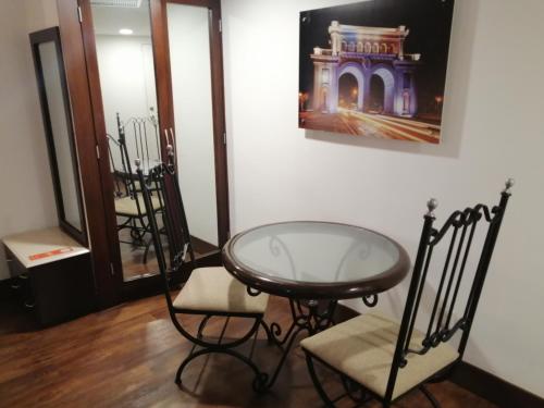 瓜达拉哈拉历史中心假日套房酒店的一间设有玻璃桌和两把椅子的房间