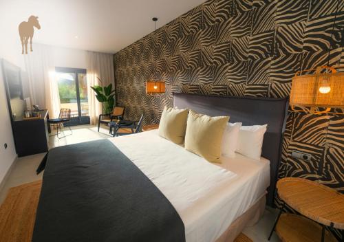 阿尔加德萨Alcaidesa Boutique Hotel的一间卧室设有一张大床和一堵图案墙