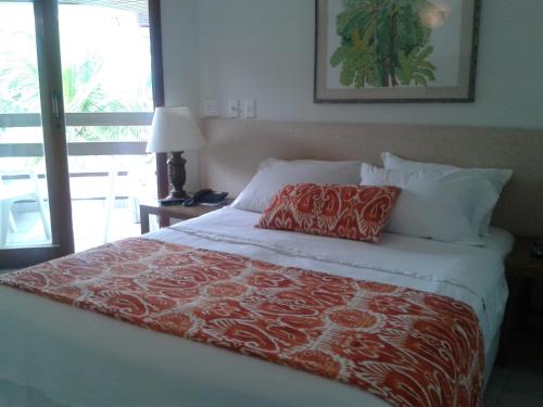 马塞约Jatiúca Resort Flat 404的一间卧室配有一张带红白毯子的床
