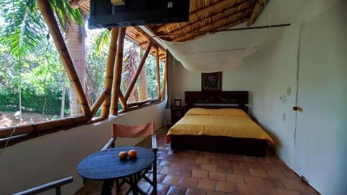 巴里查拉Cabañas Coloniales con Entorno Natural en Barichara的卧室配有床、桌子和窗户。