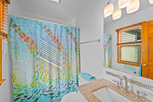奇蒂豪克R Beach House的浴室设有淋浴帘和五颜六色的孔雀浴帘