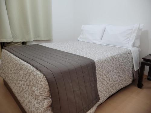 圣保罗Flat Manhattan Residence Service的一间卧室配有带白色床单和枕头的床。