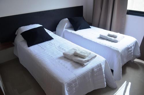 圣达菲House and Suite Premium的两张带白色床单和毛巾的床