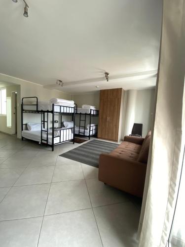 利马The Point Miraflores - Party Hostel的客厅配有两张双层床和一张沙发
