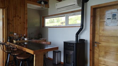 科伊艾科Cabañas Patagonia Indómita的客房内的厨房配有柜台和炉灶