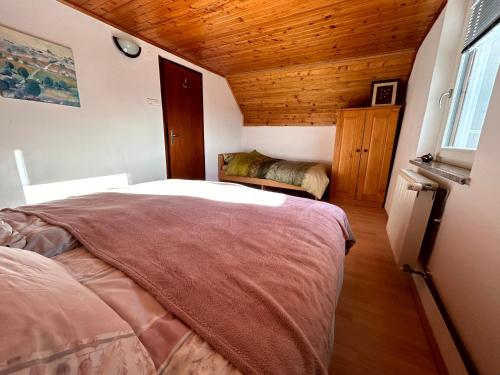 采尔克诺Apartma Bine的一间卧室设有一张床和木制天花板