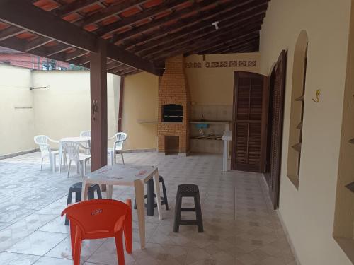 乌巴图巴Casa grande com churrasqueira - Centro Ubatuba的一个带桌椅的庭院和一间厨房