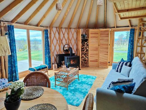 WolanyGlamping Niebiańska Osada Jurty Dolnośląskie & SPA的带沙发和壁炉的客厅