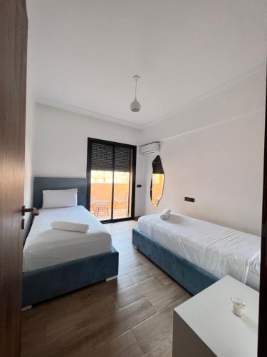 马拉喀什Nour casa de hoy的酒店客房设有两张床和窗户。