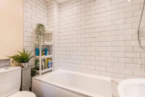 圣奥尔本斯Quiet & Secluded St Albans House的白色的浴室设有浴缸和卫生间。