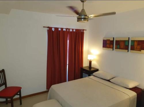 维拉卡洛斯帕兹Departamento San José IV- Villa Carlos Paz的一间卧室配有床和红色窗帘