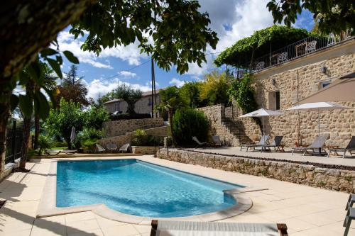 欧布纳Domaine de la Pinède的一座带椅子的庭院和一座建筑中的游泳池