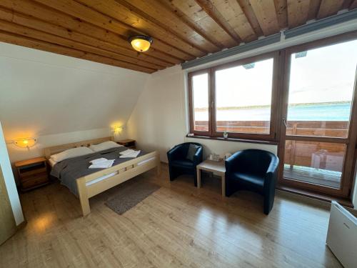 纳梅斯托沃Slanický Dvor的一间卧室配有一张床、一张桌子和两把椅子