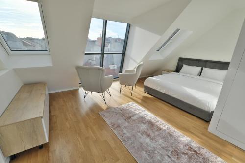 维也纳Vienna Lotus Apartments的一间卧室配有一张床、两把椅子和窗户
