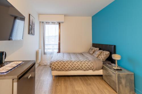 塞尔吉Le Beau Refuge Parisien de Cergy - Parisian modern flat at Cergy的一间卧室设有一张床和蓝色的墙壁