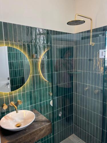 悉尼Native Rose Hotel的绿色瓷砖浴室设有水槽和淋浴