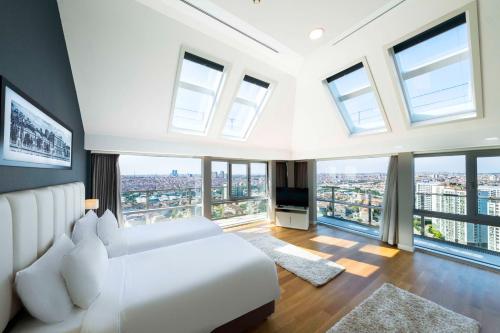 伊斯坦布尔Radisson Residences Avrupa TEM Istanbul的卧室设有白色的床和大窗户