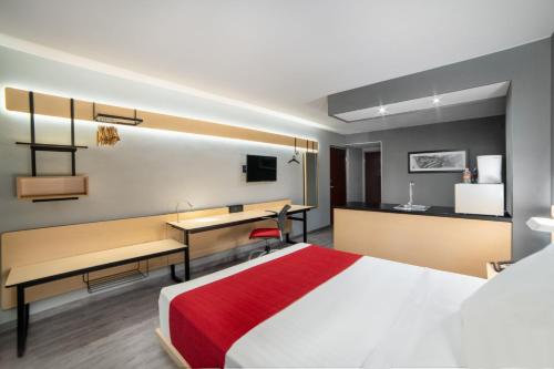 普埃布拉普埃布拉中央城市快捷酒店的配有一张床和一张书桌的酒店客房