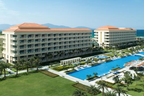 岘港Sheraton Grand Danang Resort & Convention Center的享有带游泳池的度假村的空中景致