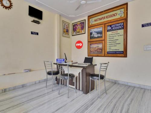 斋浦尔OYO Flagship Hotel Hastinapur Residency的配有桌椅和笔记本电脑的房间